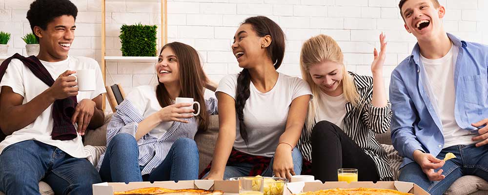 happy-teens-eating-pizza-at-party